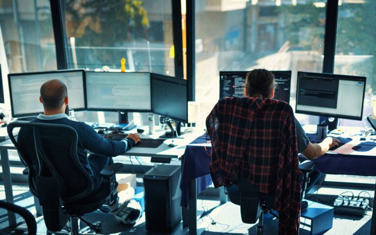 IT team monitoring client networks on multiple screens